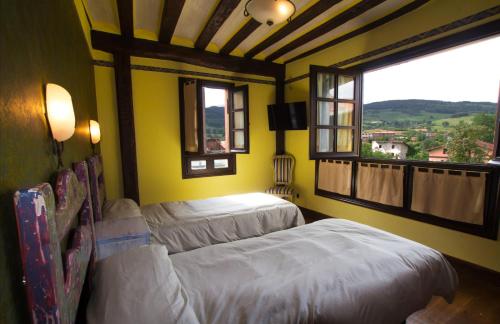 two beds in a room with a window at Lupardika in Orduña