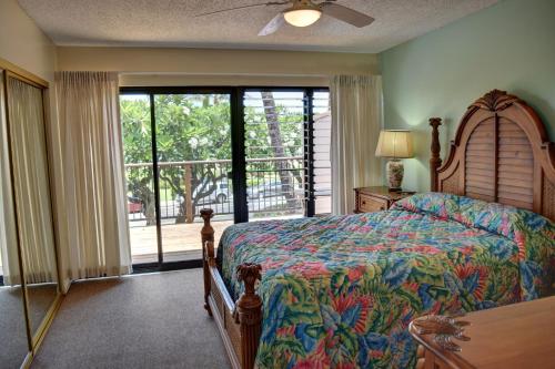 a bedroom with a bed and a large window at Kihei Akahi A104 in Wailea
