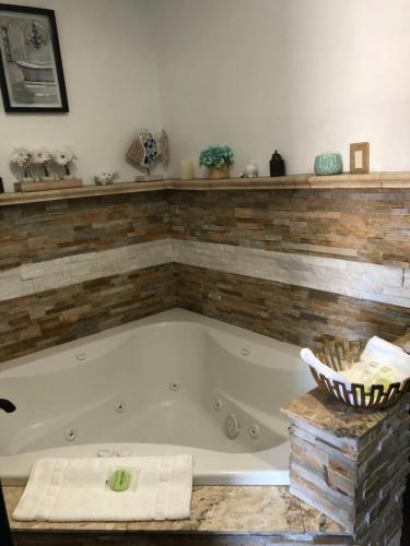 a bath tub in a bathroom with a brick wall at Dunes Motel - Bend in Bend