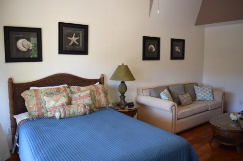 a bedroom with a bed and a couch at Kihei Bay Surf 233 in Kihei