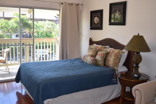 a bedroom with a bed and a balcony at Kihei Bay Surf 233 in Kihei