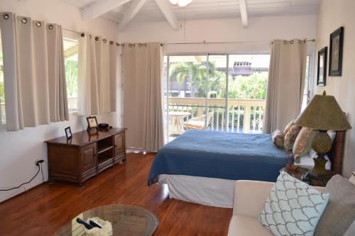 a bedroom with a bed and a couch and a window at Kihei Bay Surf 233 in Kihei