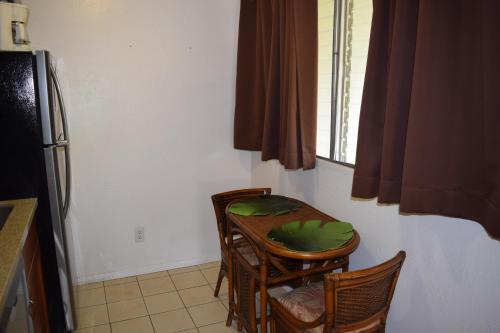 a kitchen with a table and chairs and a refrigerator at Kihei Bay Surf 233 in Kihei