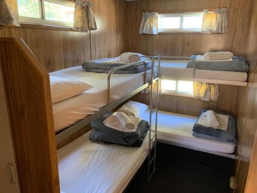 a group of four bunk beds in a room at Koonwarra Holiday Park in Lakes Entrance