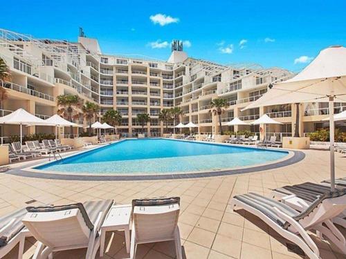 un gran edificio de apartamentos con una gran piscina en Ocean Panorama - 1 Bedroom Oceanview Apt, en Ettalong Beach