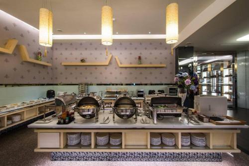 a restaurant with a counter with plates on it at Shianghu Boutique Hotel in Chiayi City