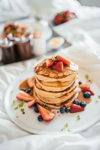 a stack of pancakes with strawberries and blueberries on a plate at Pullman Sydney Olympic Park in Sydney
