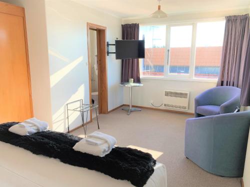 a hotel room with a bed and a chair at Ranfurly Hotel in Ranfurly