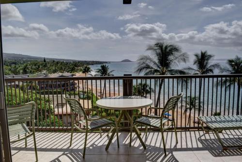 a balcony with a table and chairs and the ocean at Mana Kai 710C in Wailea