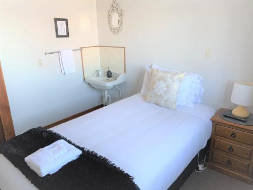 a small bedroom with two beds and a sink at Ranfurly Hotel in Ranfurly