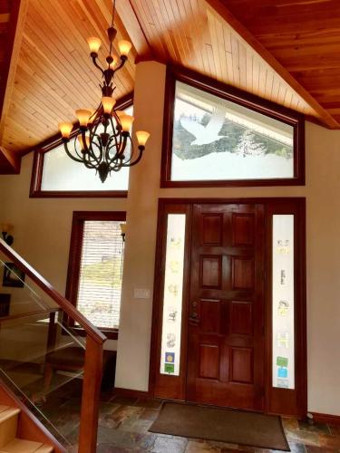 a house with a wooden door and a chandelier at High Hopes Bed and Breakfast in Hope