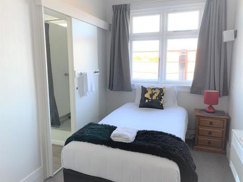 a bedroom with a white bed and a window at Ranfurly Hotel in Ranfurly