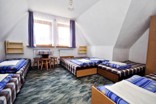Habitación con 4 camas y mesa. en Pokoje Gościnne U Marysi, en Zakopane