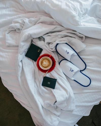 a bed with a cup of coffee and socks and a cup of coffee at Novotel Sydney Olympic Park in Sydney