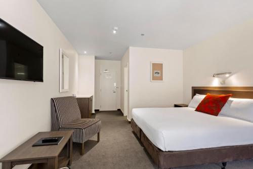 a hotel room with a bed and a chair at The Hermitage Hotel Mt Cook in Mount Cook Village