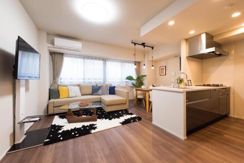 a kitchen and living room with a couch and a table at HIZ HOTEL Ginza in Tokyo
