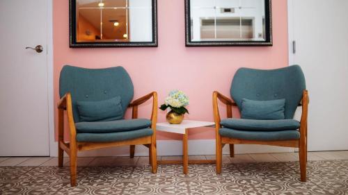 two chairs and a table with a vase of flowers at Casa Boutique Hotel in Miami Beach