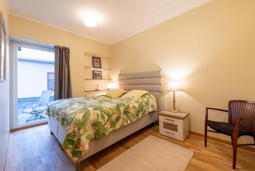 a bedroom with a bed and a chair and a window at Tähe Apartment in Tartu
