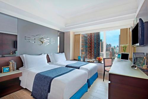 una camera d'albergo con un grande letto e una finestra di Harbour Plaza 8 Degrees a Hong Kong