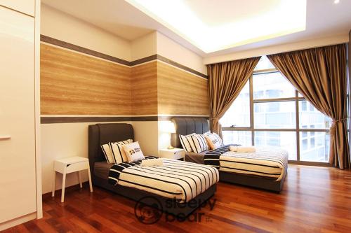 a bedroom with two beds and a couch at Azure Residences by Sleepy Bear Paradigm Mall in Petaling Jaya