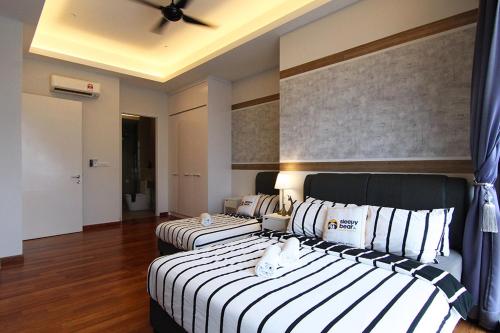 a bedroom with two beds with white and black stripes at Azure Residences by Sleepy Bear Paradigm Mall in Petaling Jaya