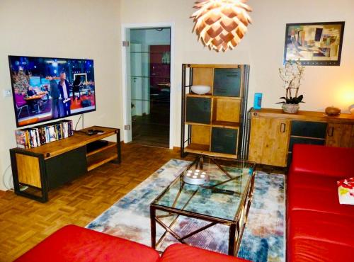a living room with a red couch and a tv at Exklusives Wohnen am Stadtpark in Bad Driburg