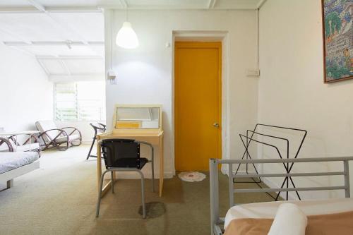 a room with a desk and chairs and a yellow door at Bellevue The Penang Hill Hotel, Bukit Bendera in Ayer Itam