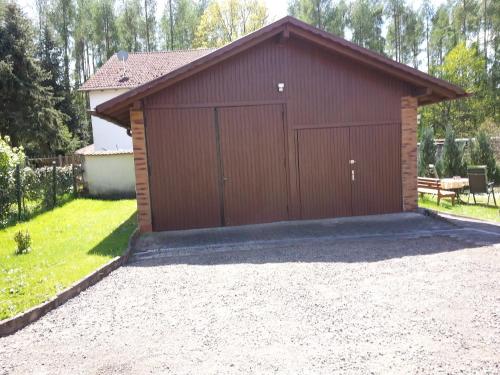 a large brown garage with a driveway at Ferienhaus Rabold in Bad Liebenstein