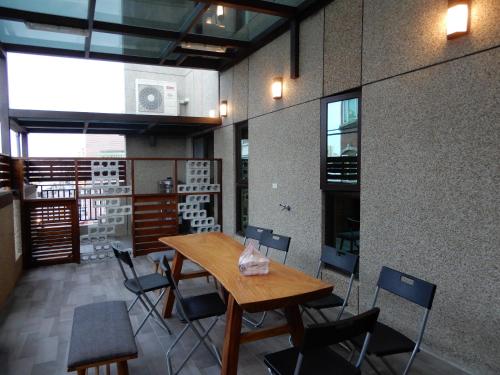 comedor con mesa de madera y sillas en Happy Wing Guesthouse, en Hualien City