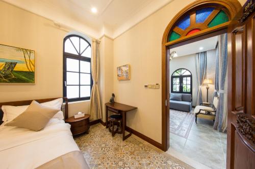 a bedroom with a bed and a desk and a window at Lansheng yard in Xiamen