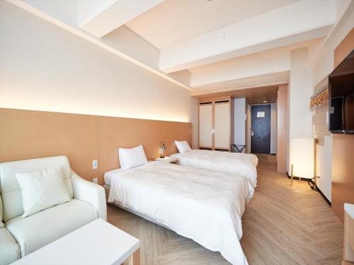 a hotel room with two beds and a couch at Palace In Moon Beach in Onna