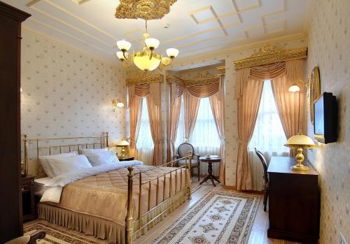 a bedroom with a bed and a chandelier at Darussaade Hotel Old City - Sultanahmet in Istanbul