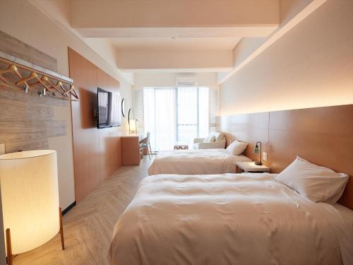 a hotel room with two beds and a window at Palace In Moon Beach in Onna