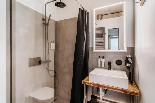 uma casa de banho com um lavatório e um chuveiro em THE HEARTS HOTEL - dein Boutique- und Event-Resort em Braunlage