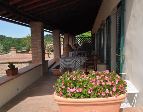 a large pot of flowers sitting on a porch at Hotel Villa Casalecchi in Castellina in Chianti