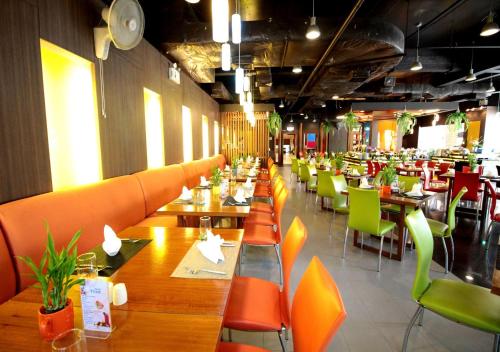 un ristorante con tavoli di legno e sedie verdi di The Seasons Pattaya a Centro di Pattaya