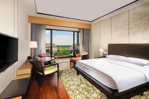 a bedroom with a large bed and a large window at Hyatt Regency Chongming in Chongming