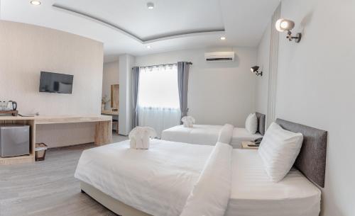 een hotelkamer met 2 bedden en een bank bij Peppy Hotel-pepperyhills hotel in Chiang Mai