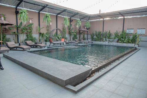 a pool in a building with chairs and a table at Peppy Hotel-pepperyhills hotel in Chiang Mai