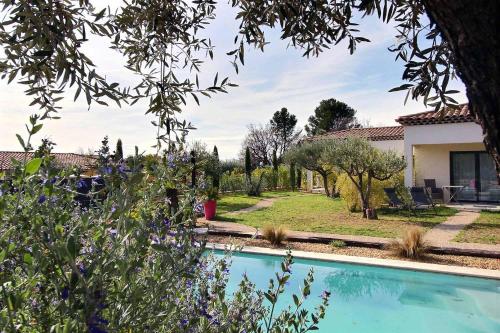 a house with a swimming pool in a yard at La Villa Aux Oliviers in Flayosc