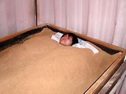 a young boy laying in a bed with his head sticking out at Ryokan Kume Himawari Sou in Sakaide