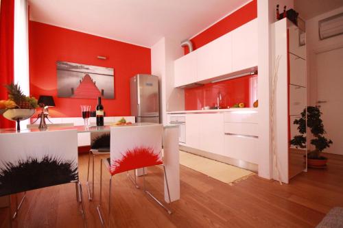 a kitchen with red walls and a table and chairs at Apartment Villa Mandria in Opatija