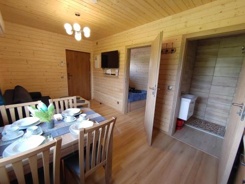 a dining room with a table and chairs in a cabin at Apartamenty przy Jeziorze Żywieckim z widokiem na Skrzyczne in Żywiec