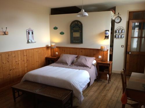 1 dormitorio con cama blanca y mesa en Bed&B La Ferme De L'ostrevent, en Estrées