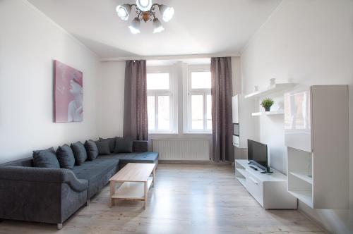 uma sala de estar com um sofá e uma televisão em Downtown Apartments em Praga