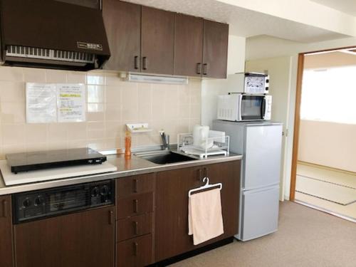a kitchen with a sink and a refrigerator at Fuji Gotemba Condominium Tannpopo in Gotemba
