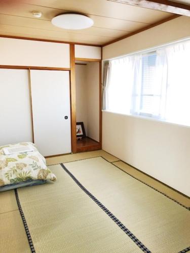a bedroom with a bed and a large window at Fuji Gotemba Condominium Tannpopo in Gotemba