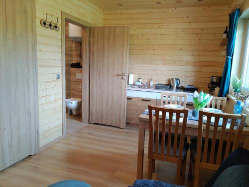 a kitchen with a dining table and a bathroom at Apartamenty przy Jeziorze Żywieckim z widokiem na Skrzyczne in Żywiec