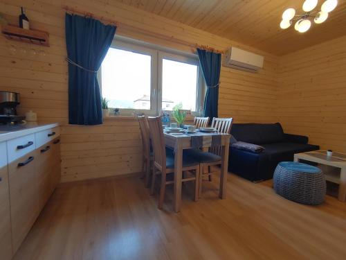 a kitchen and living room with a table and a couch at Apartamenty przy Jeziorze Żywieckim z widokiem na Skrzyczne in Żywiec