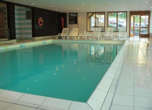 a large swimming pool with chairs in a building at CHALET DE BOIS MEAN in Les Orres